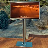 Self standing mount outdoor TV with cloudy orange sky on the screen in a wooden deck outside in Oman.